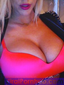 La rubia sonriente Xo Gisele está jugando con sus enormes pechos frente a la cámara.